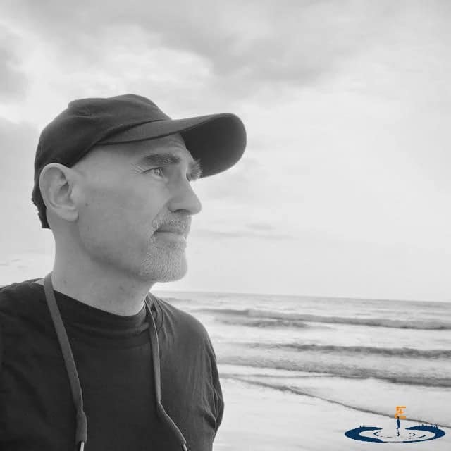 Fundador de Esteyan, contemplando el horizonte en una playa al amanecer, simbolizando la visión y la claridad estratégica